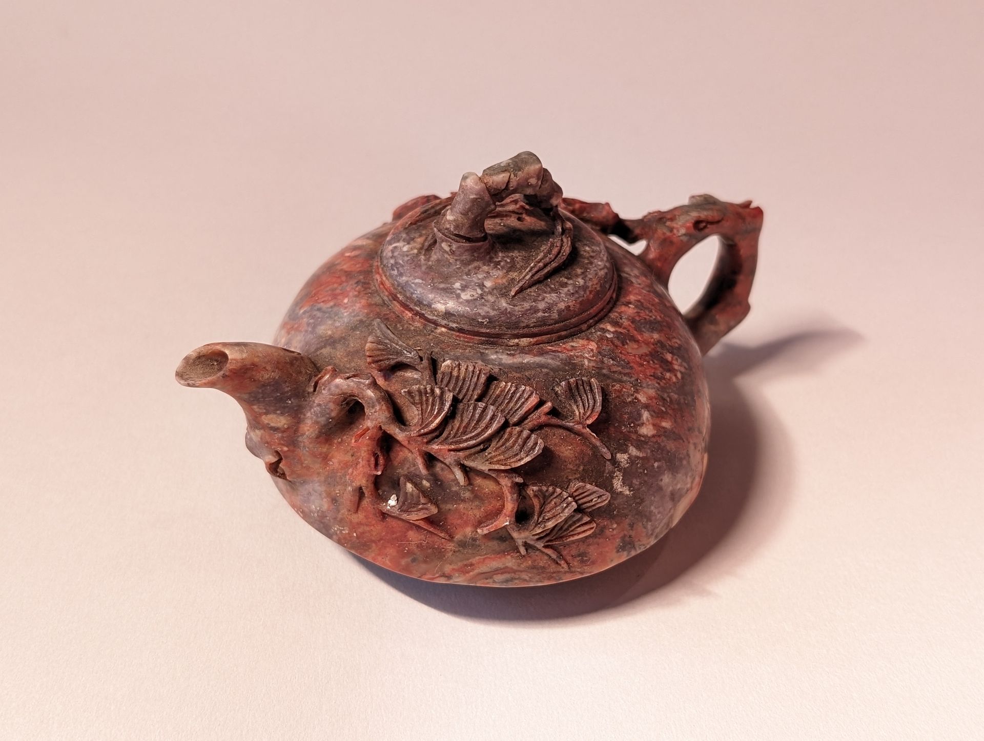 Antique reddish-brown teapot with floral relief, shown on a pale background