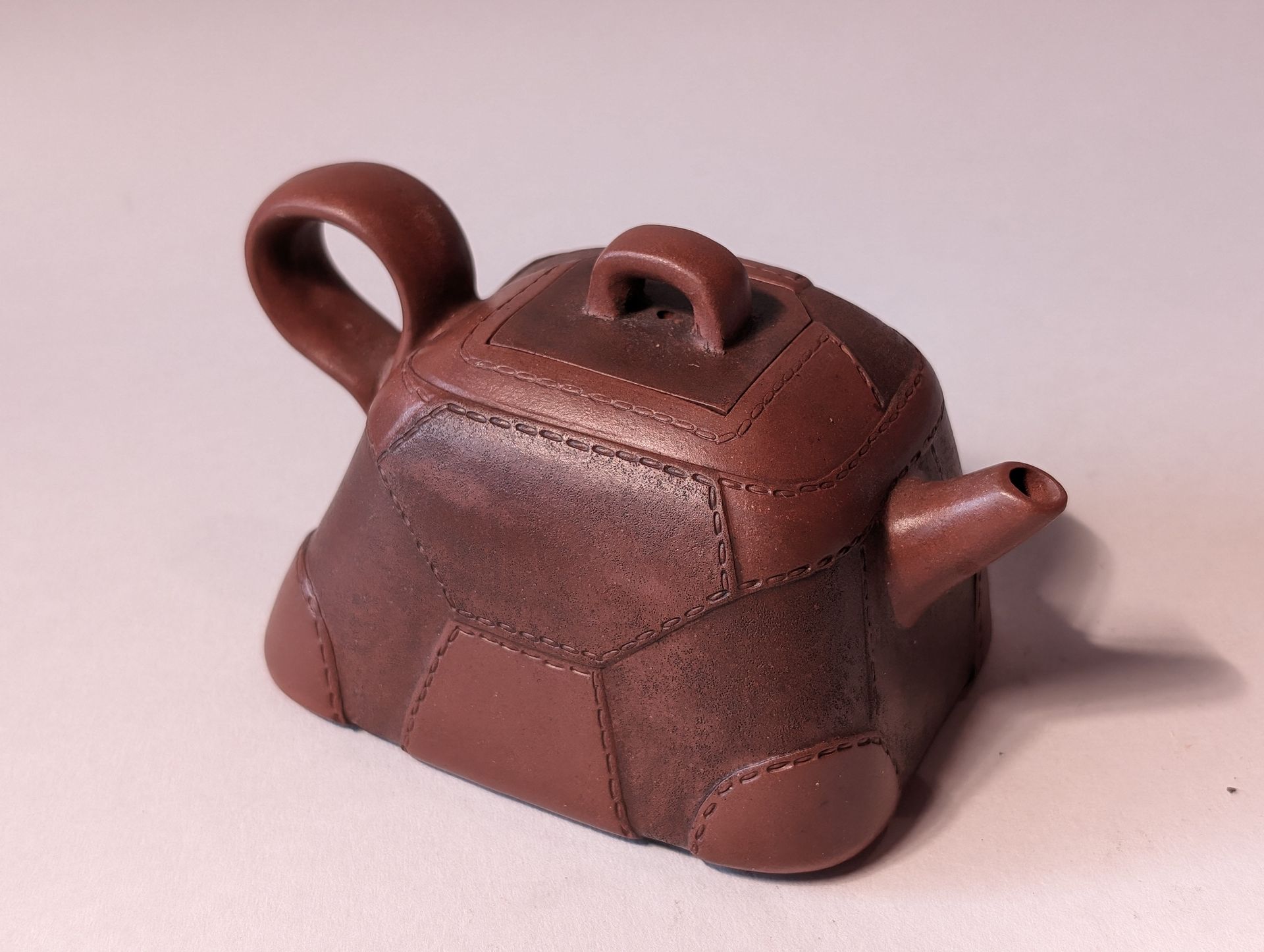 Small brown ceramic teapot with a loop handle and short spout, shaped like a tiny house