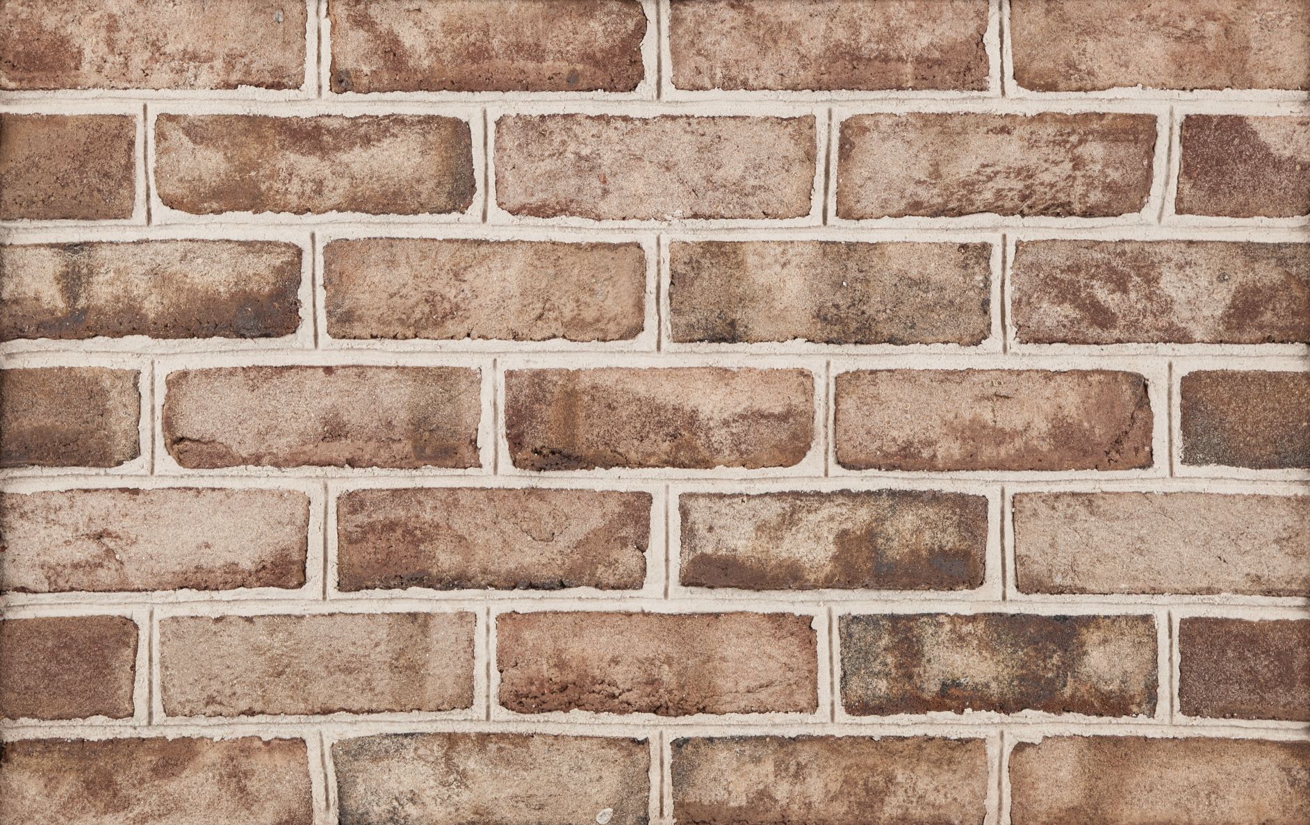 Close-up of a brick wall with varying shades of brown bricks and white mortar.