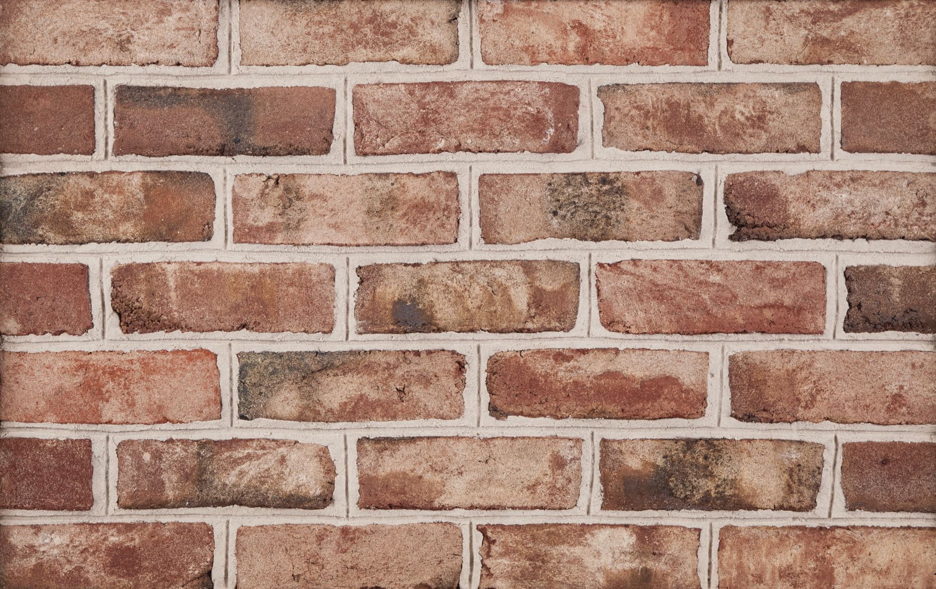 Red and brown brick wall with white mortar.