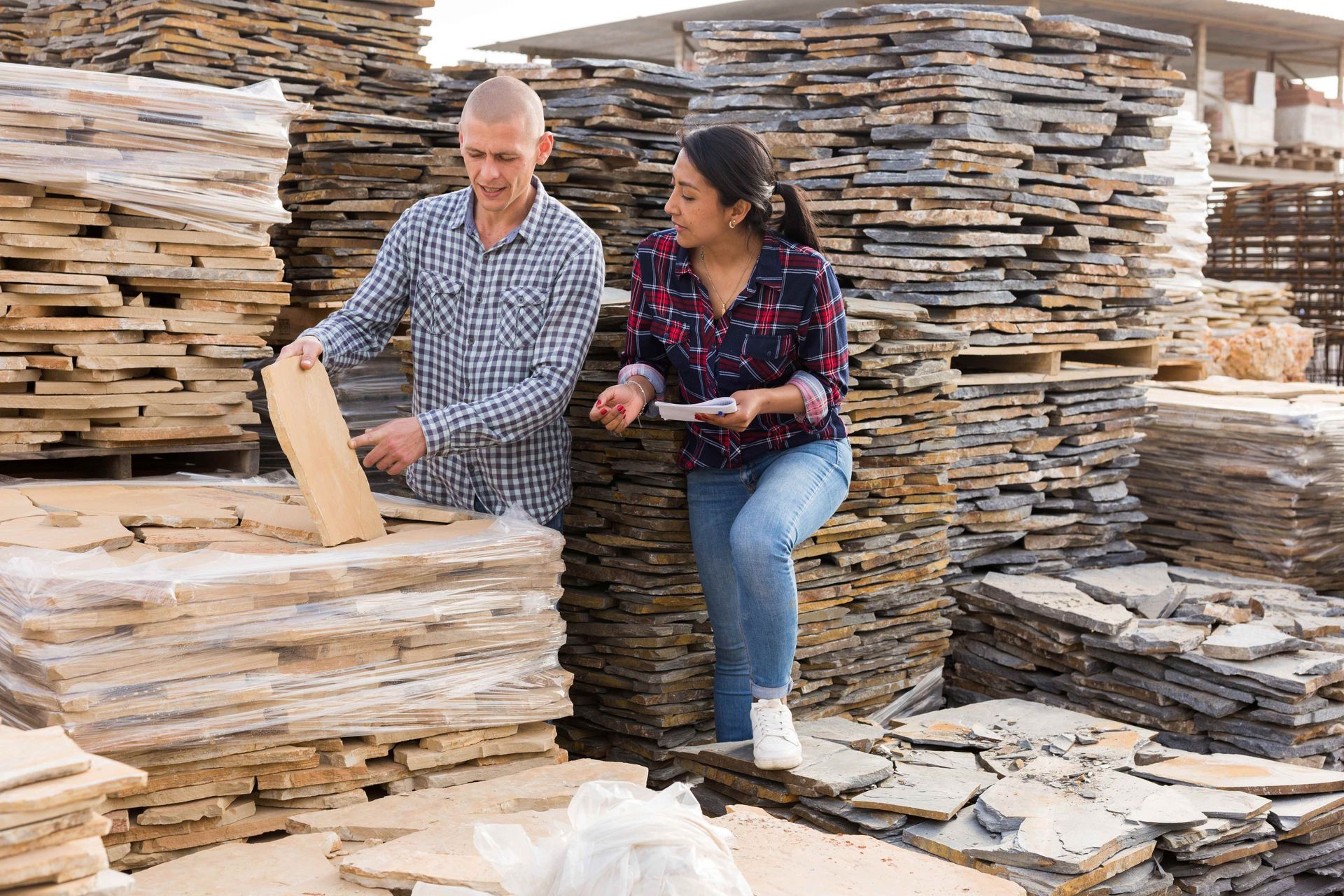 Two buyers choosing natural stone tiles at a supplier.
