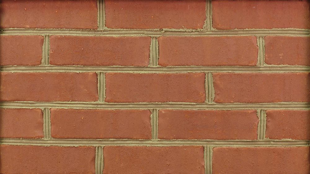 Close-up of a brick wall, red bricks with light brown mortar.