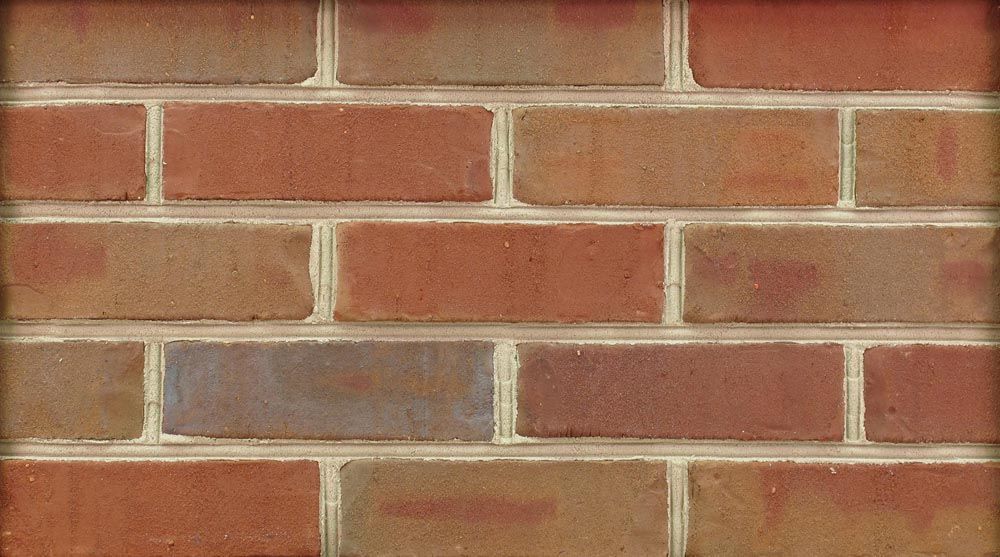 Close-up of a brick wall, red and brown bricks with light mortar.