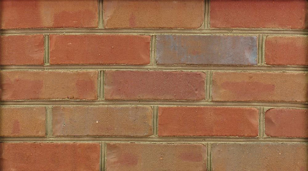 Red and tan brick wall with mortar.