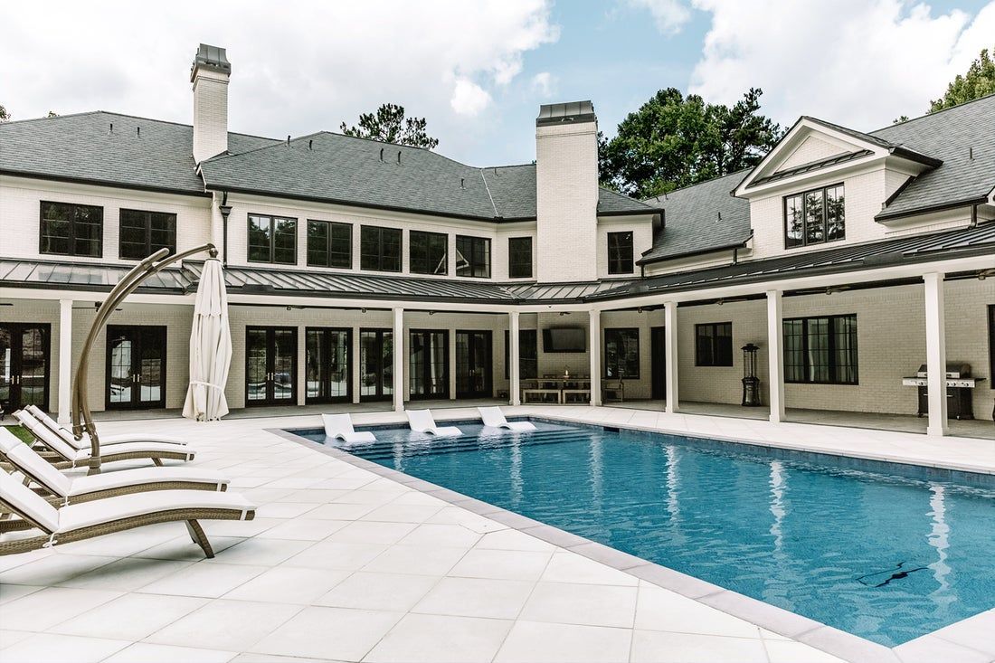 Luxury home exterior with a swimming pool and patio area.