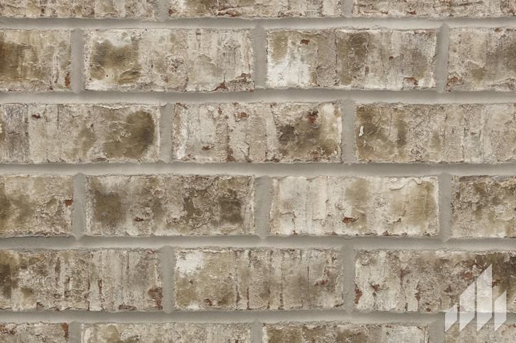 Close-up of weathered brick wall with varying shades of brown and gray.