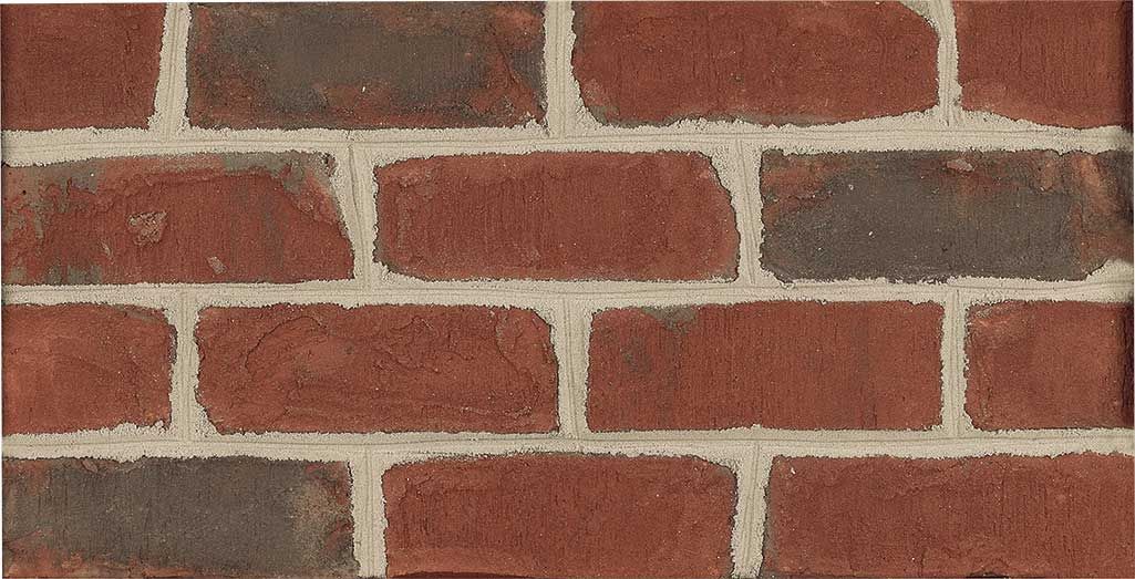 Red brick wall with gray and tan mortar.