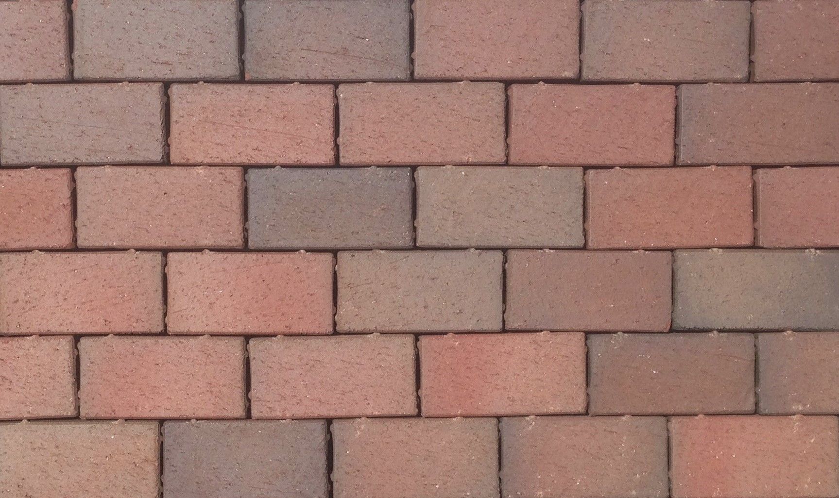 Brick pavement with alternating reddish-brown and gray rectangular bricks.