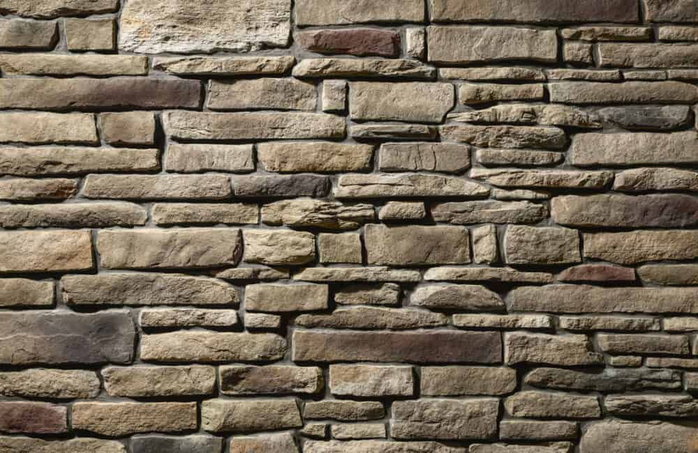 Stone brick wall with tan, brown, and gray rectangular stones.