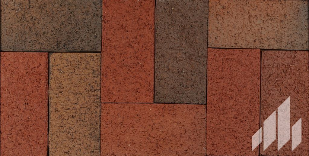 Close-up of a brick paver pattern with rectangular brown, orange, and red bricks arranged in a random pattern.