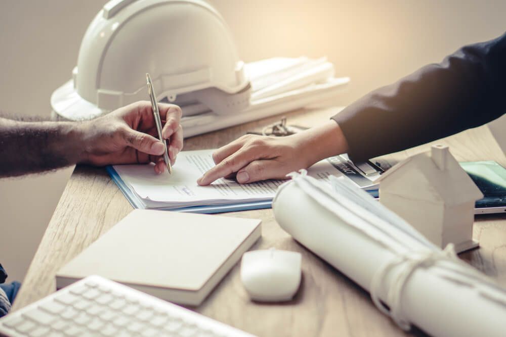 A Man Is Writing on A Piece of Paper While a Woman Looks On — Marks Financial Group in  Toowoomba City, QLD