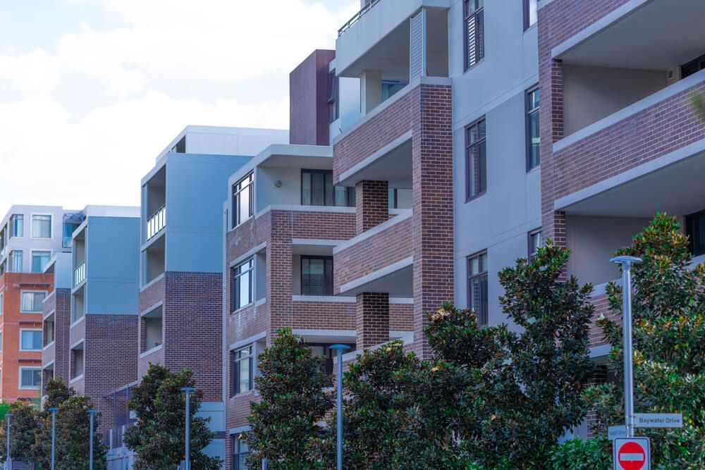 A Row of Apartment Buildings with Trees in Front of Them — Marks Financial Group in  Toowoomba City, QLD