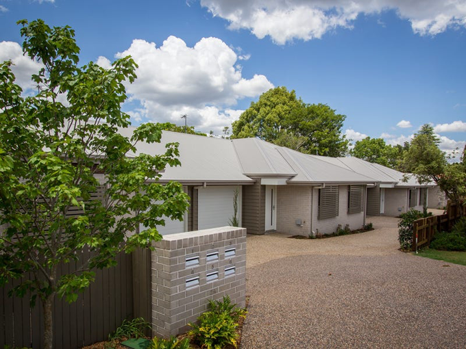 A Row of Apartment Buildings with A Lush Green Lawn in Front of Them — Marks Financial Group in Toowoomba City, QLD