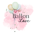 Vor einem rosa Hintergrund hängt ein Bündel Luftballons an einer Schnur.
