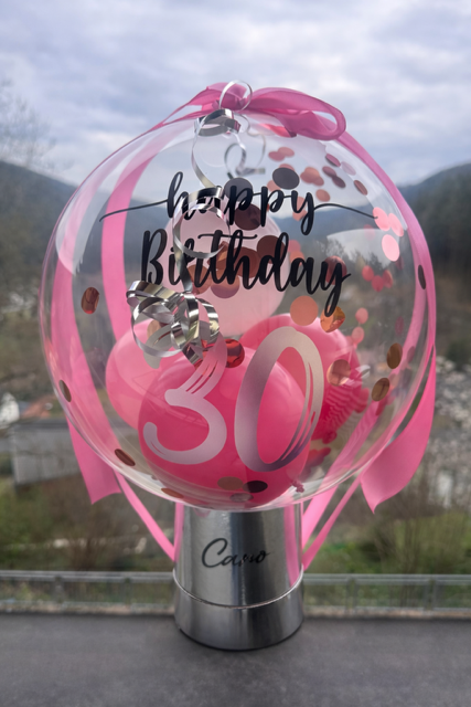 Ein Ballonbogen in Weiß, Rosa und Silber schmückt einen Türrahmen.