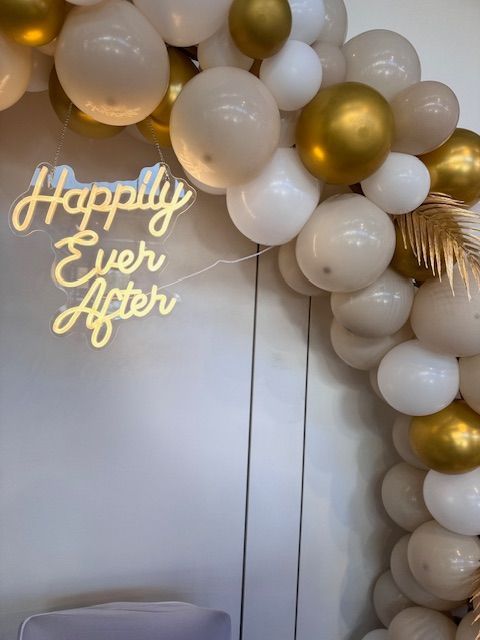 Ein Heißluftballon gefüllt mit gelben Ballons und Blumen auf einem Tisch.
