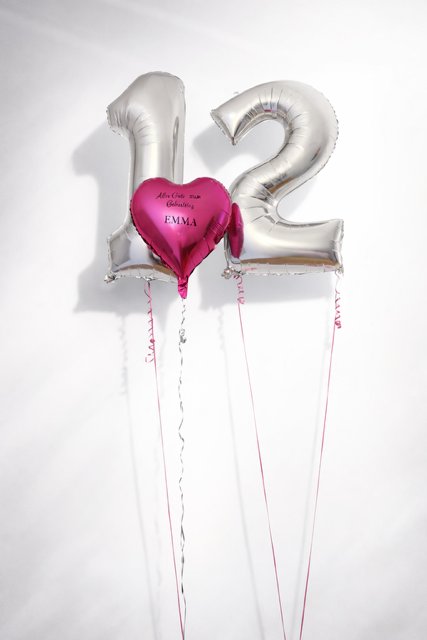 Auf einem Tisch steht ein durchsichtiger Ballon mit der Aufschrift „Schulkind 2023“.