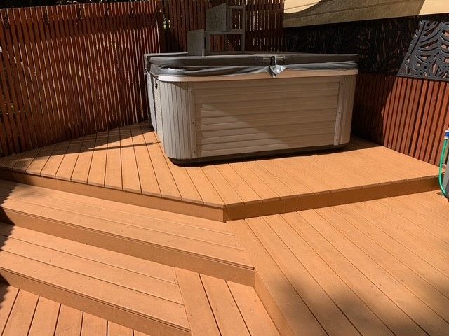 A hot tub is sitting on top of a wooden deck.