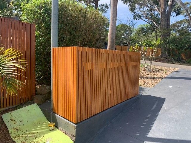 A wooden fence with a green chair in front of it.