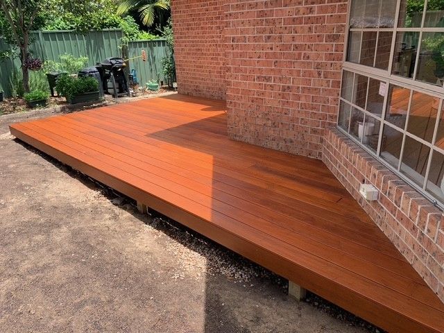 A wooden deck is sitting in front of a brick building.