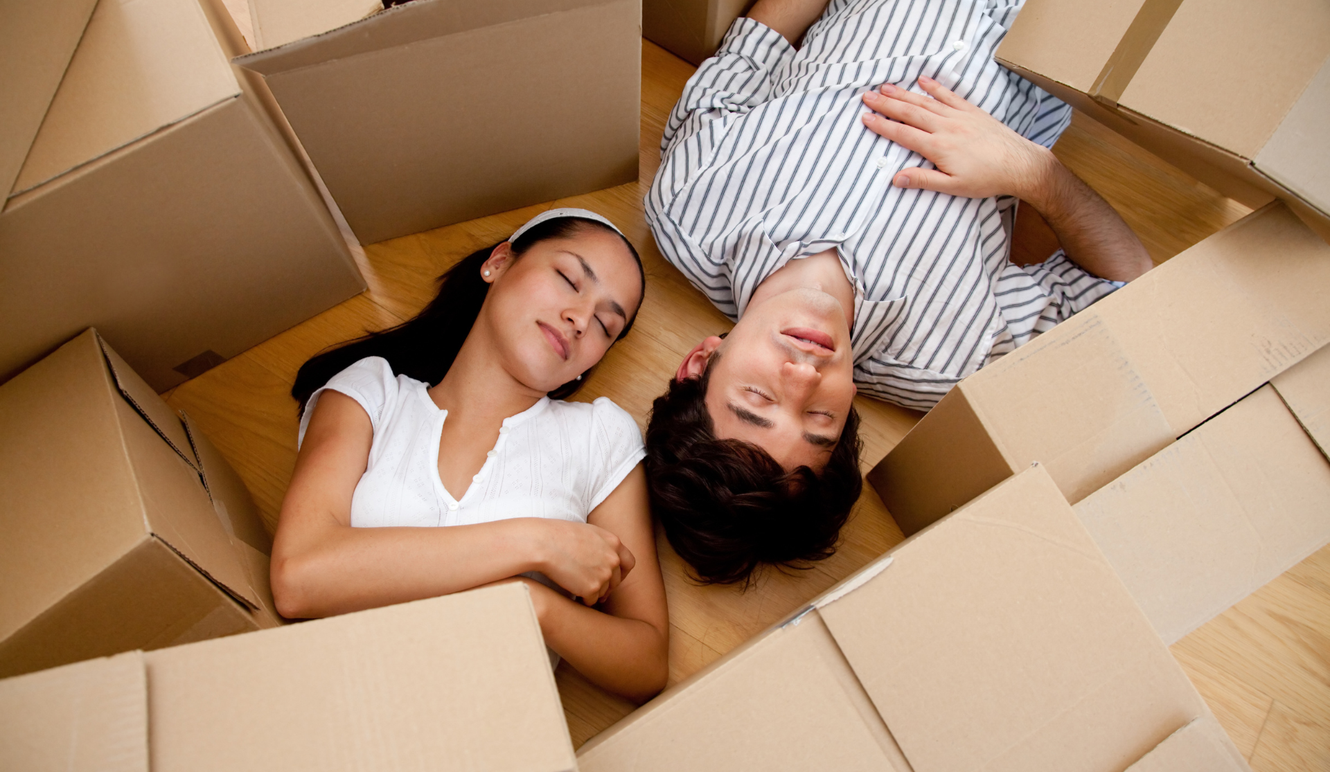 Un homme et une femme sont allongés épuisés dans une pile de cartons.