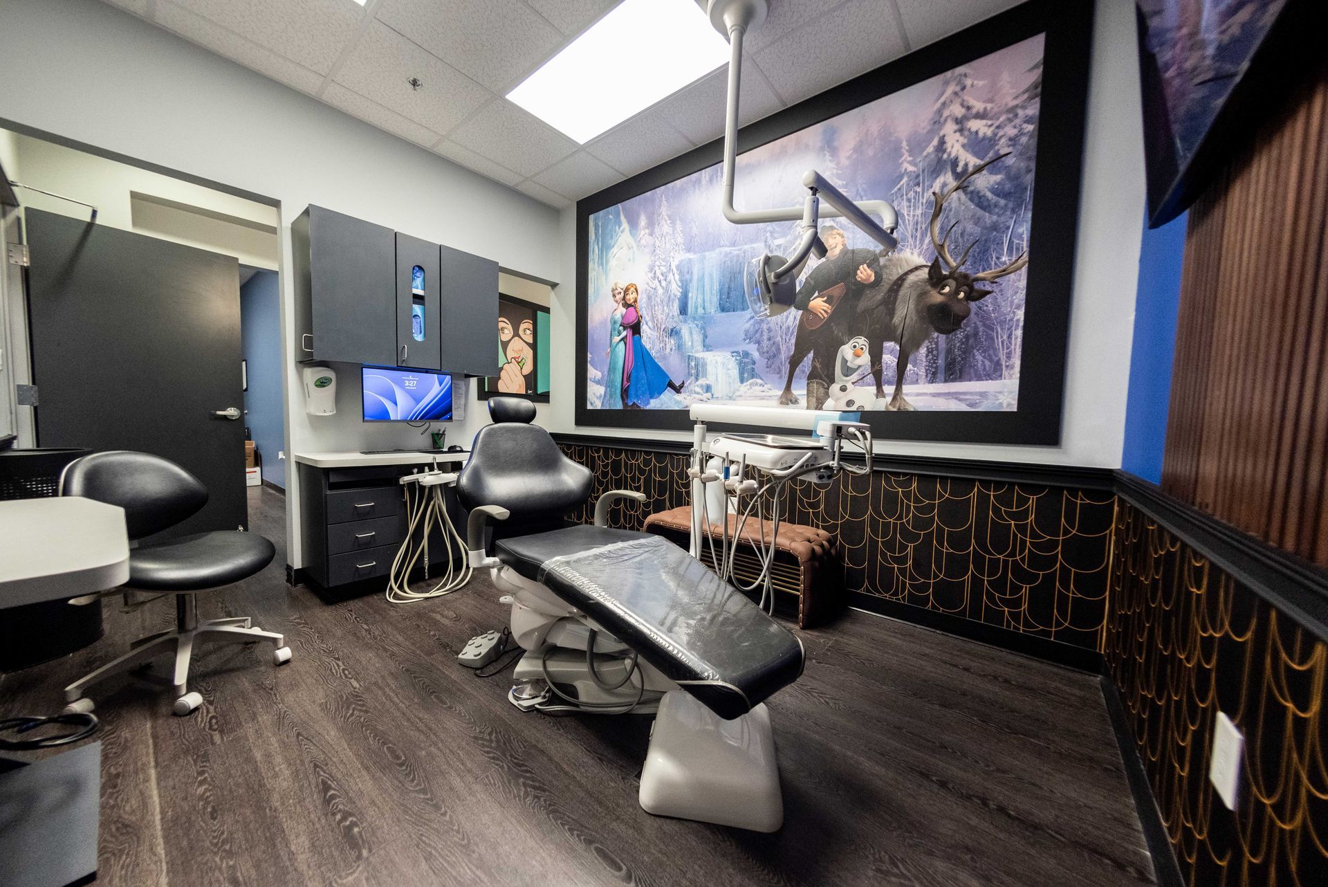 Modern dental exam room with chair, monitor, and wall mural of a horse and rider