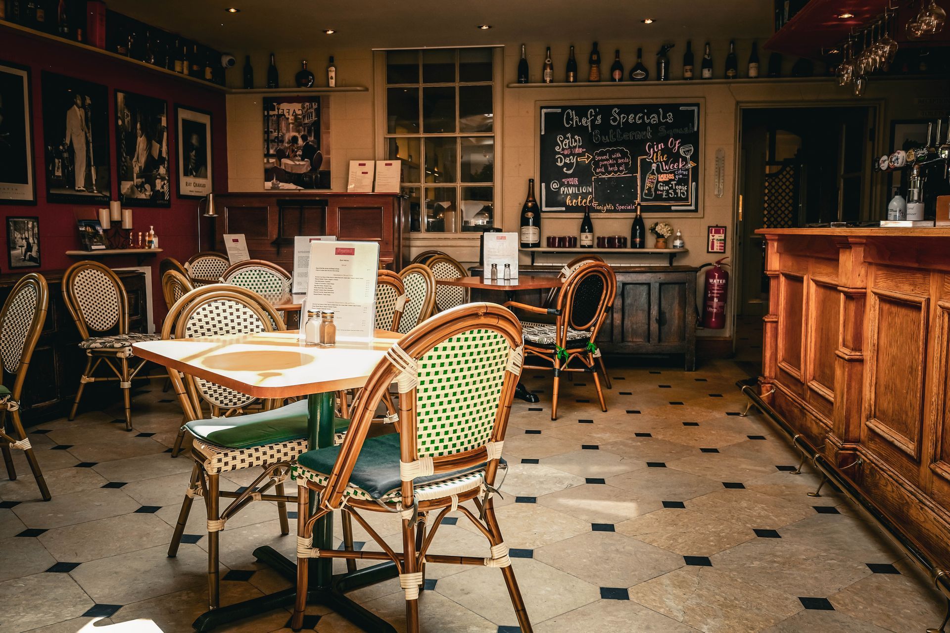 A restaurant with tables and chairs and a bar.