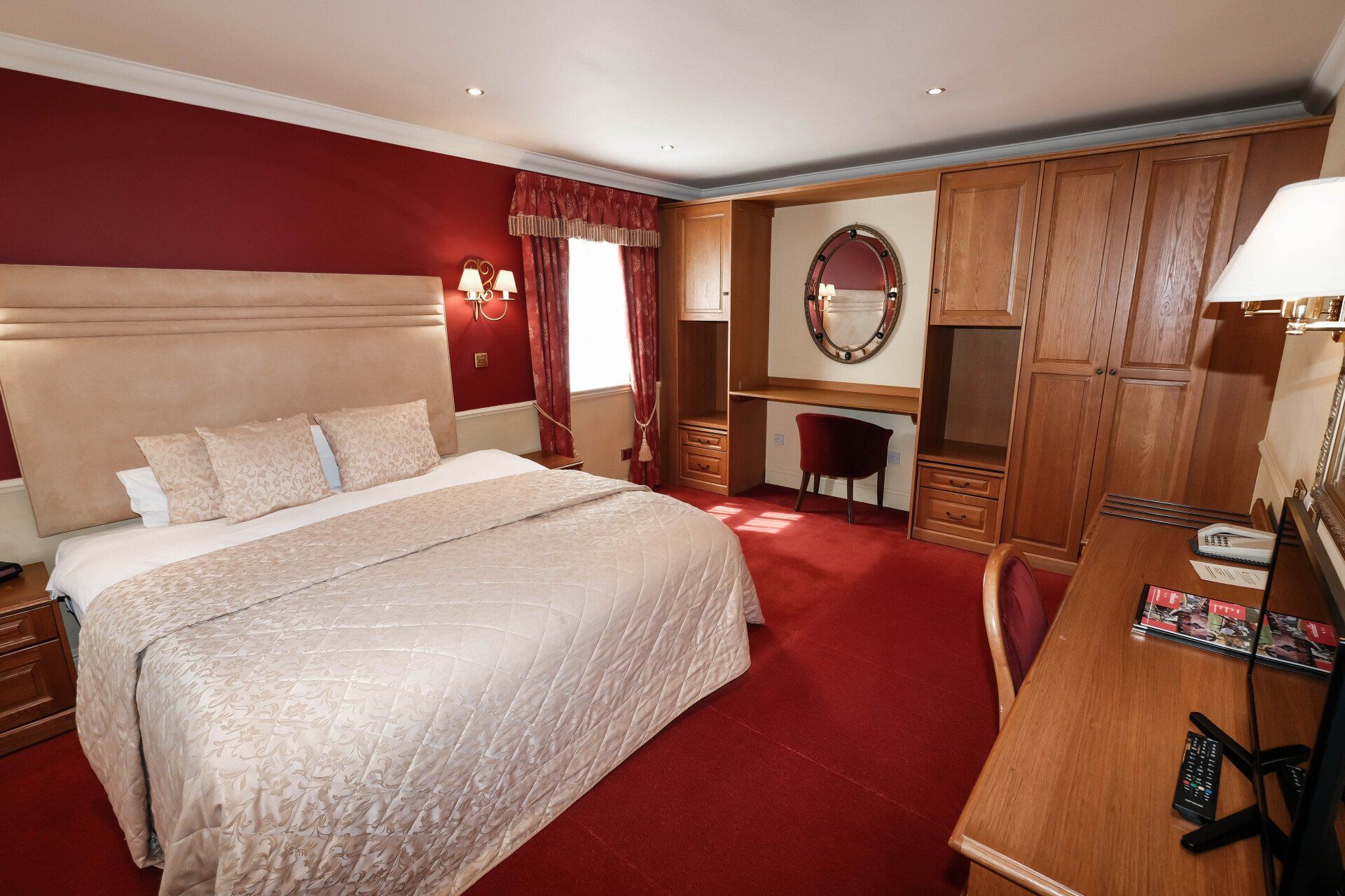 A hotel room with a large bed and a desk