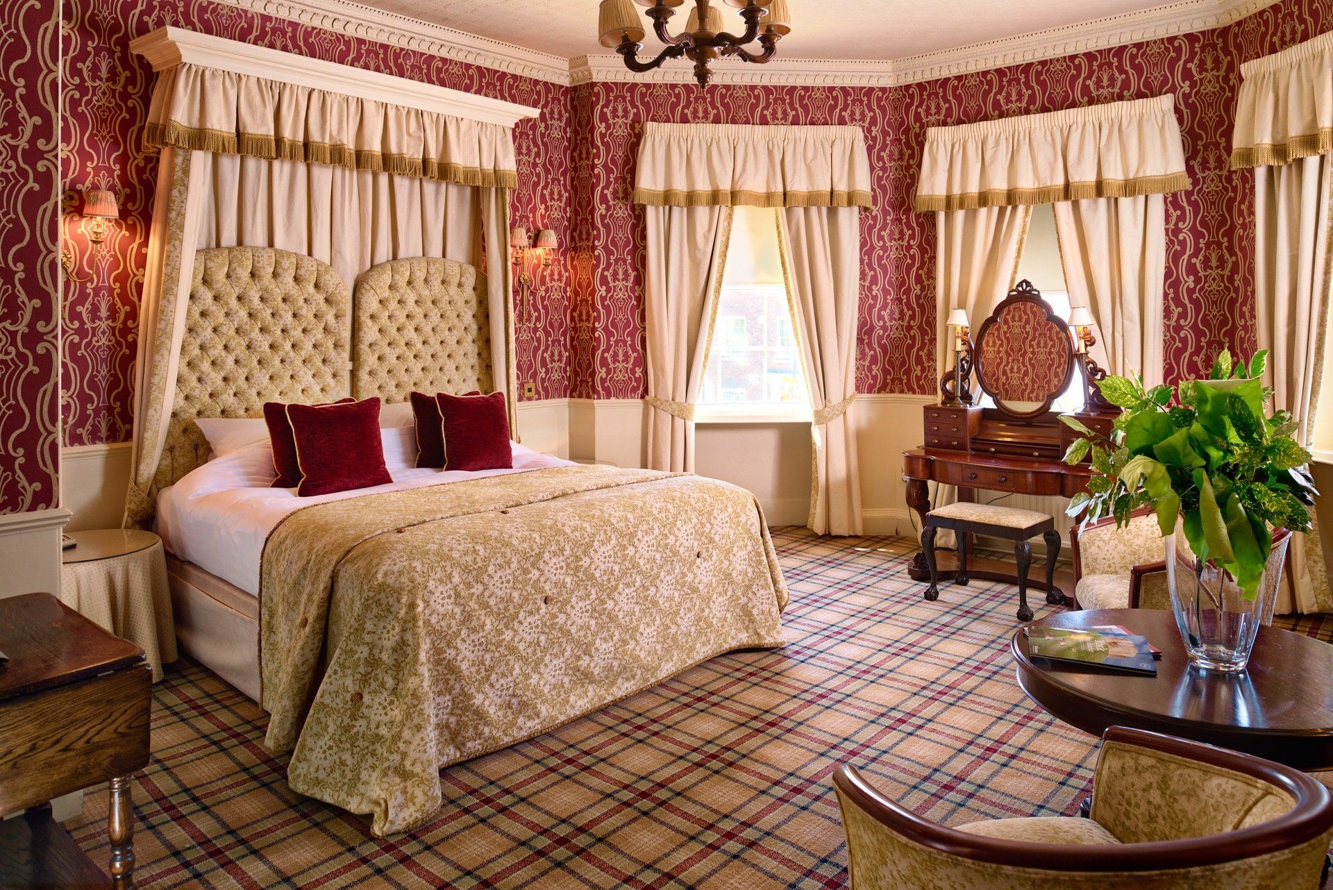 A hotel room with a canopy bed and a table.