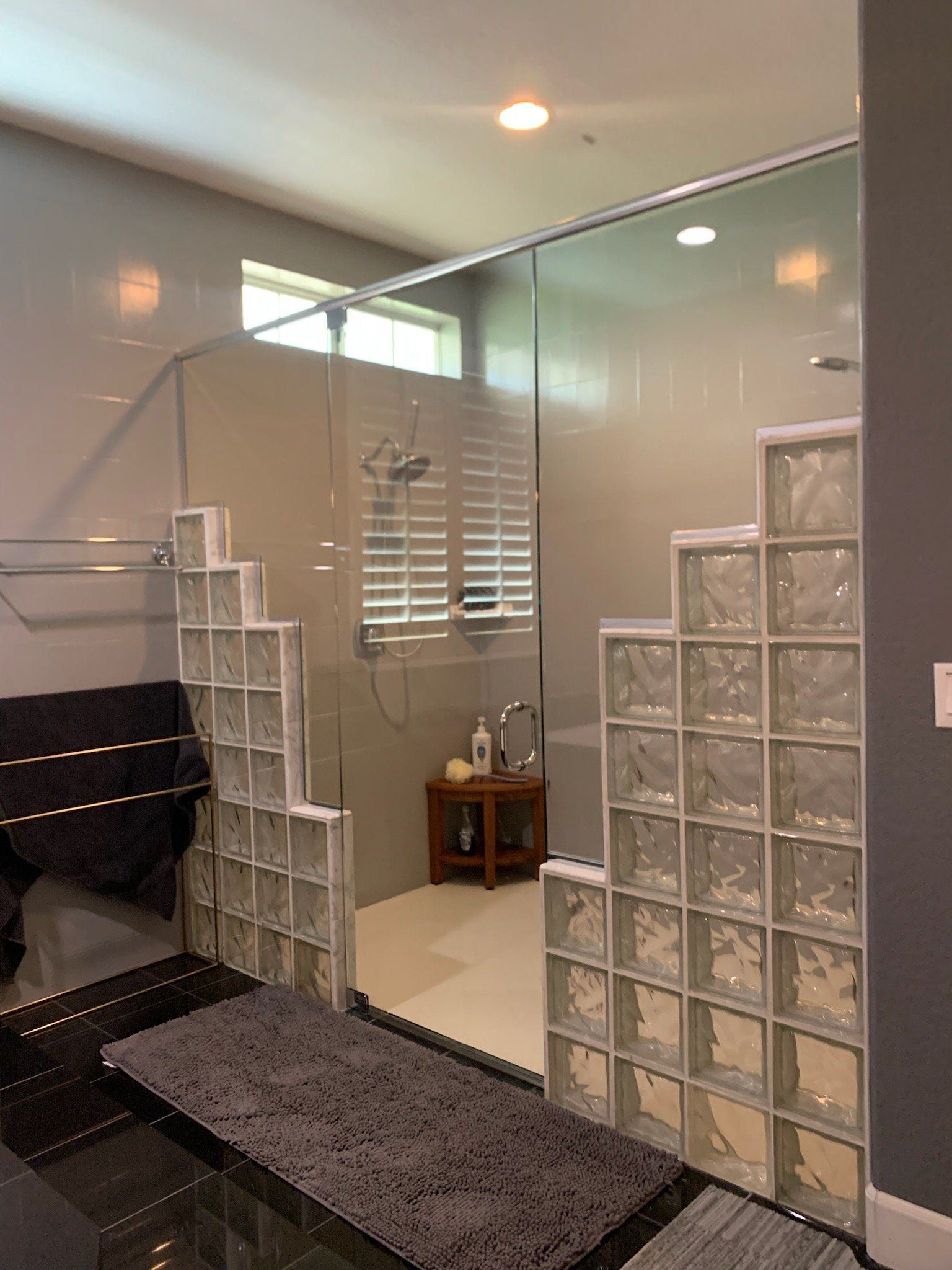 A bathroom with a walk in shower surrounded by glass blocks.