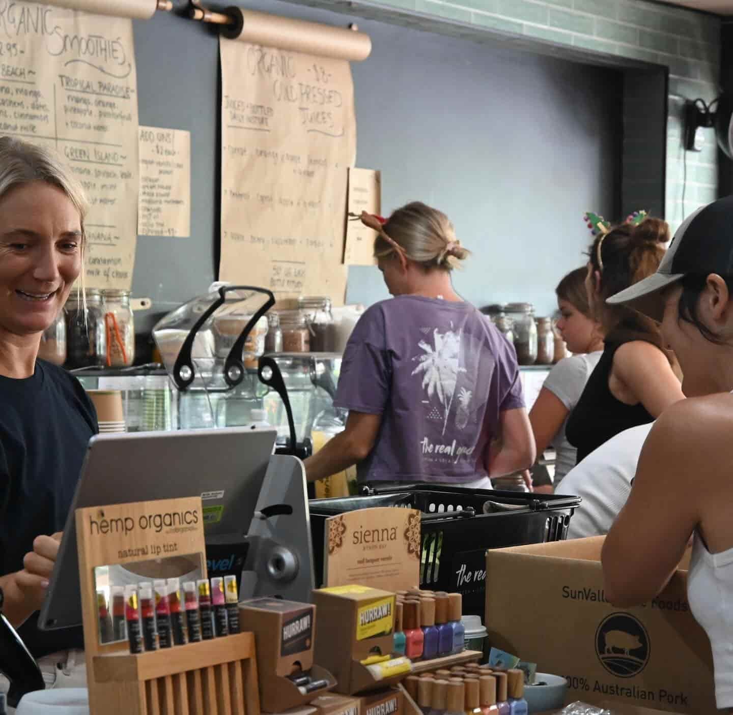 A Woman In A Purple Shirt With A Flower On It — The Real Grocer In Golden Beach, QLD