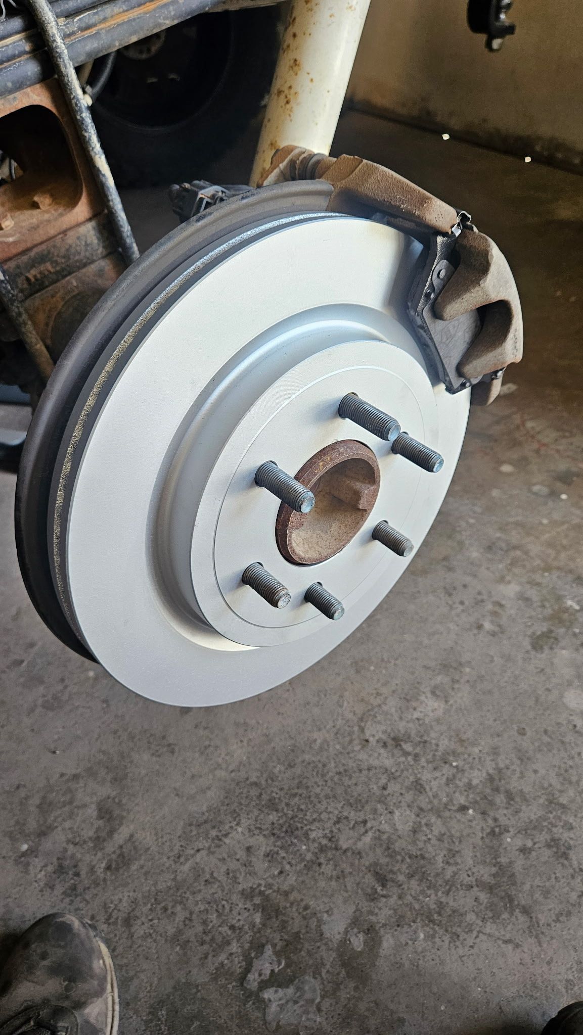 The image displays a newly installed disc brake assembly on a vehicle.