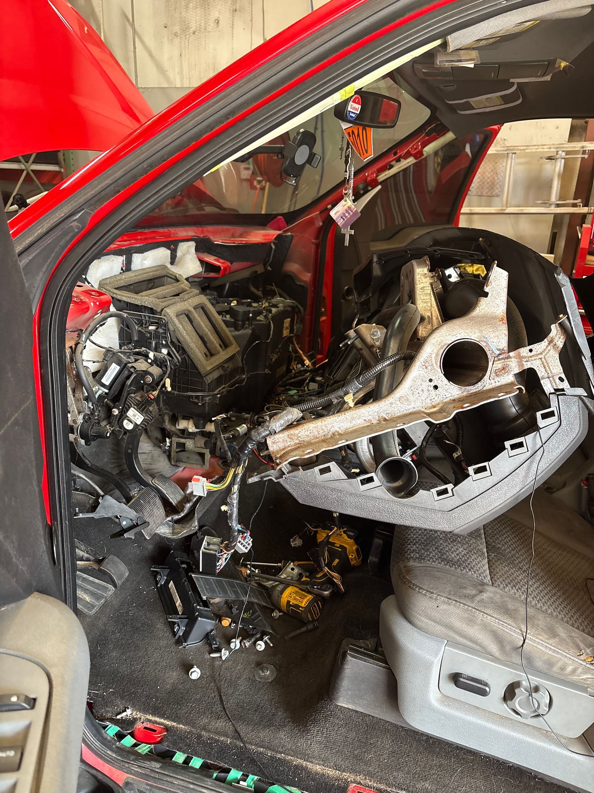 The image shows a vehicle's dashboard fully disassembled for a major repair, likely the replacement of an AC evaporator core.