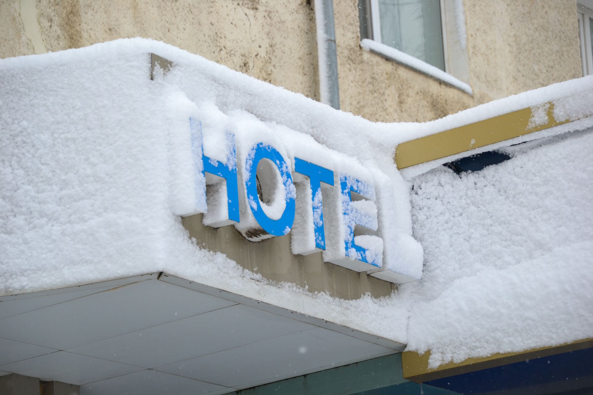 Hotel entrance sign covered in fresh snow after heavy snowfall