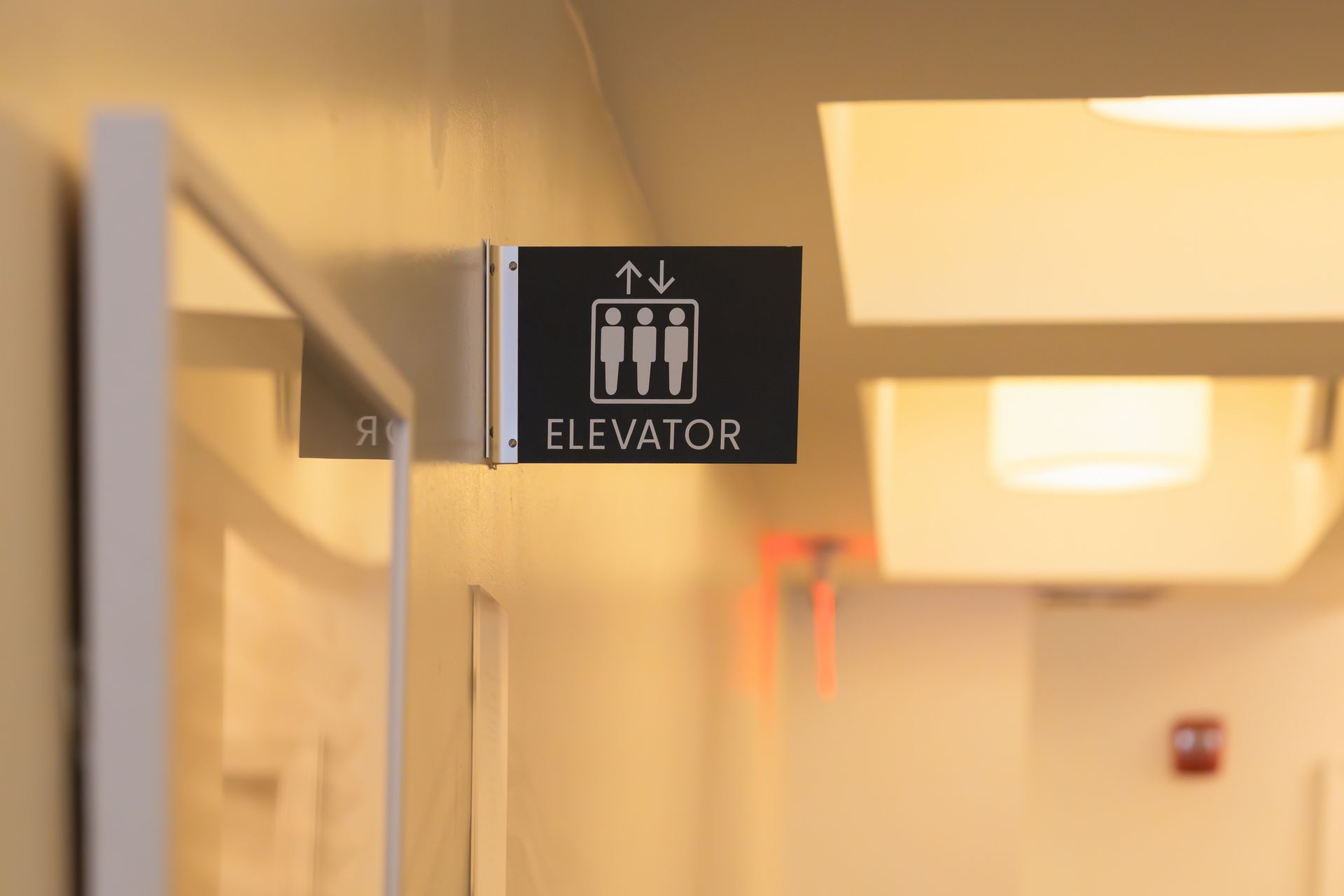 Elevator sign in a well-lit hallway. Elevator sign in a well-lit hallway.