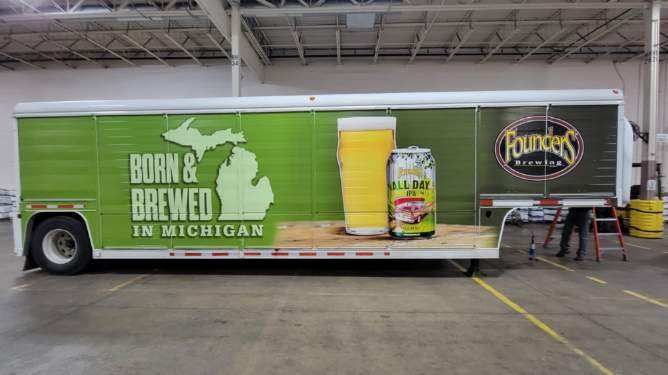 Green Founders Brewing Co. trailer with Michigan outline, beer can and glass illustrations; 