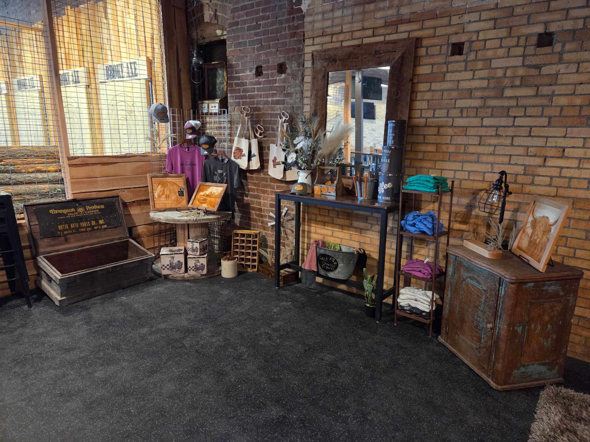 Rustic room with vintage furniture, brick wall, mirrors, shelves, and assorted decor items