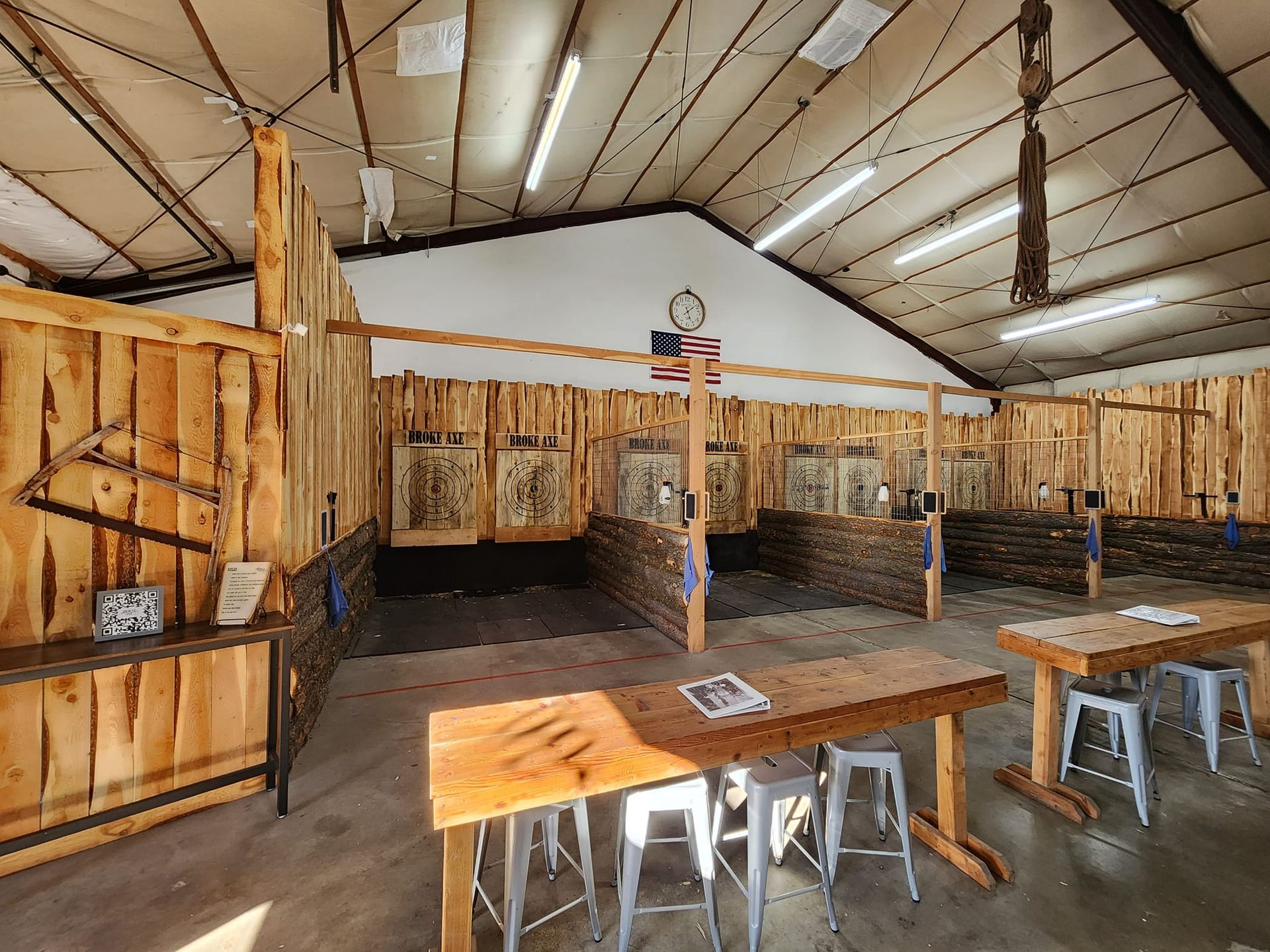 Open-air rustic café with wooden tables, stools, and a corrugated metal roof