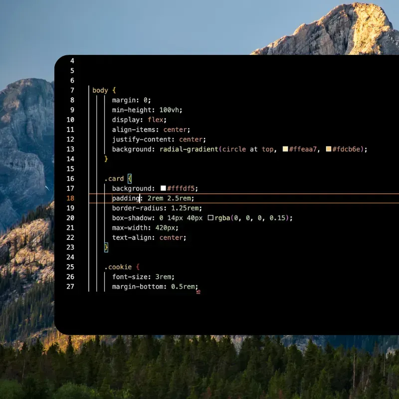 Code editor with CSS open on a black window over a mountain desktop wallpaper
