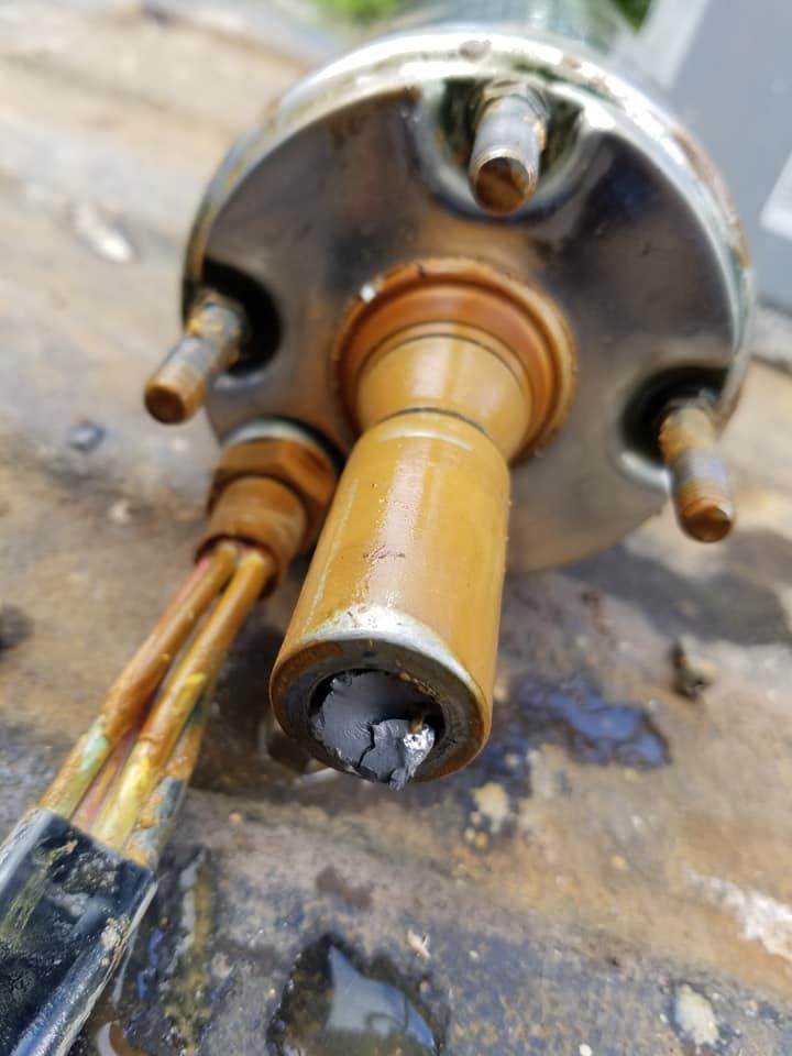 Close-up of a damaged water heater component with copper pipes and a cylindrical core with a broken end. Close-up of a damaged water heater component with copper pipes and a cylindrical core with a broken end.