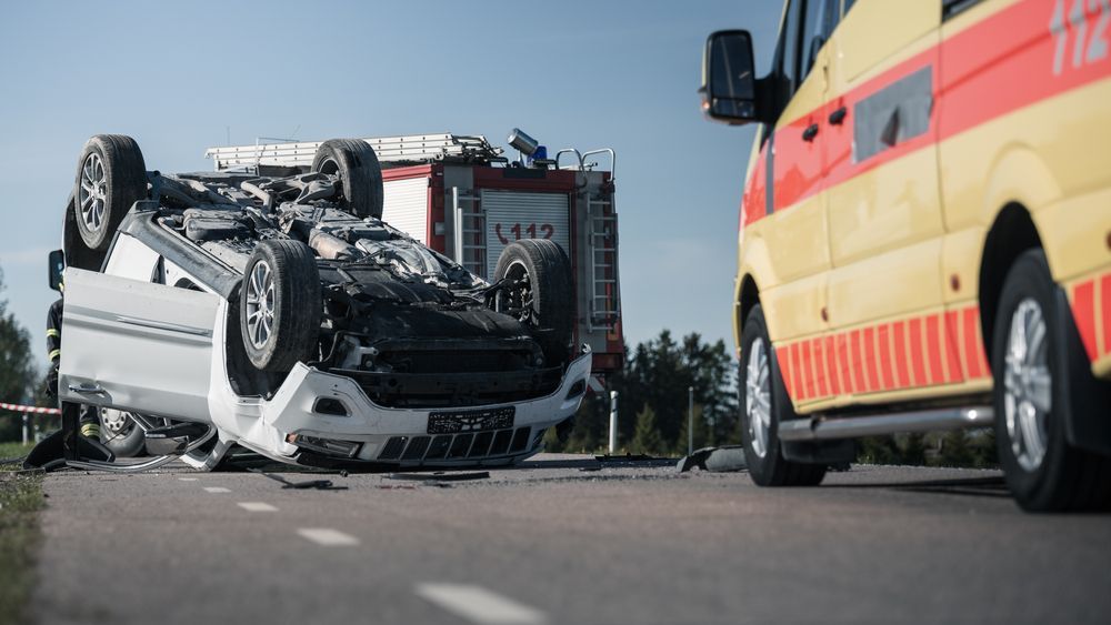 Overturned vehicle on a highway with emergency responders at the scene of a serious accident