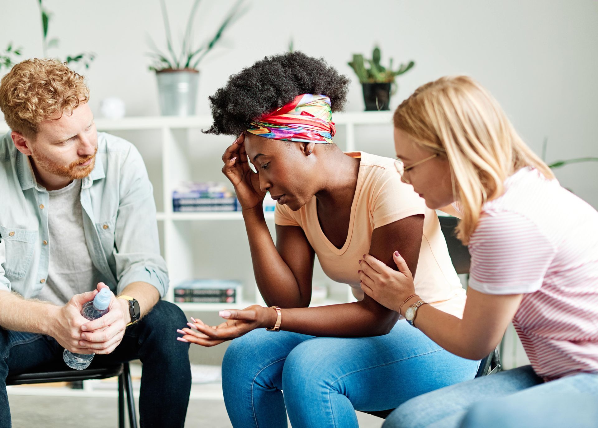 A group of people are sitting around a woman who is crying after a New Jersey car accident