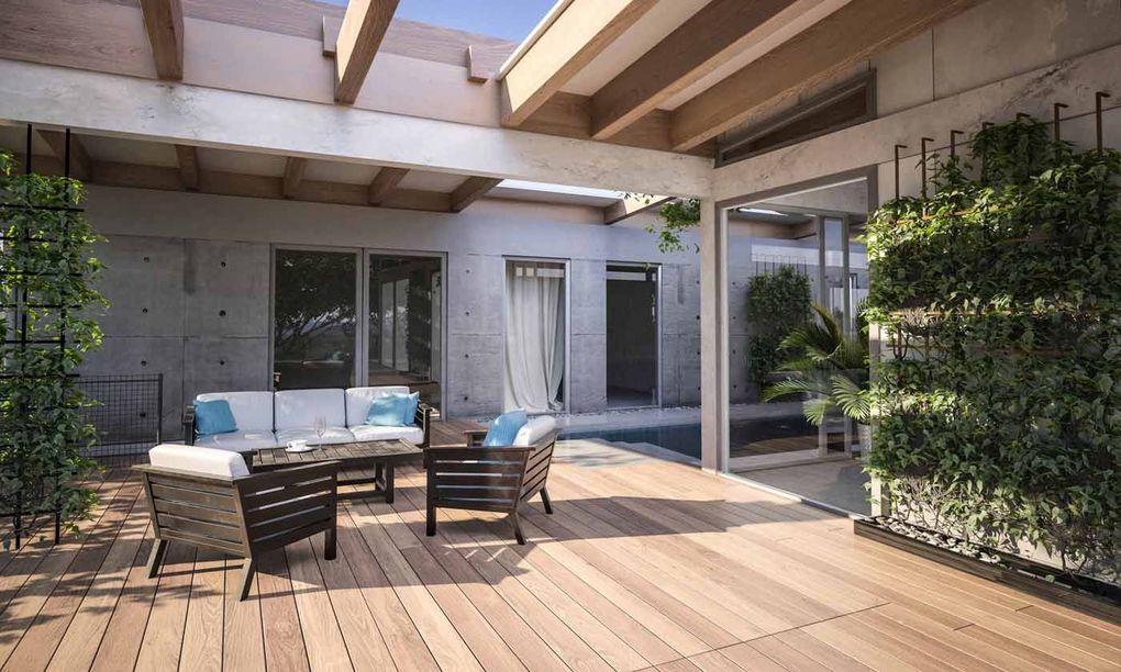 Modern patio with wooden deck, white sofa, dining table, and greenery under a pergola