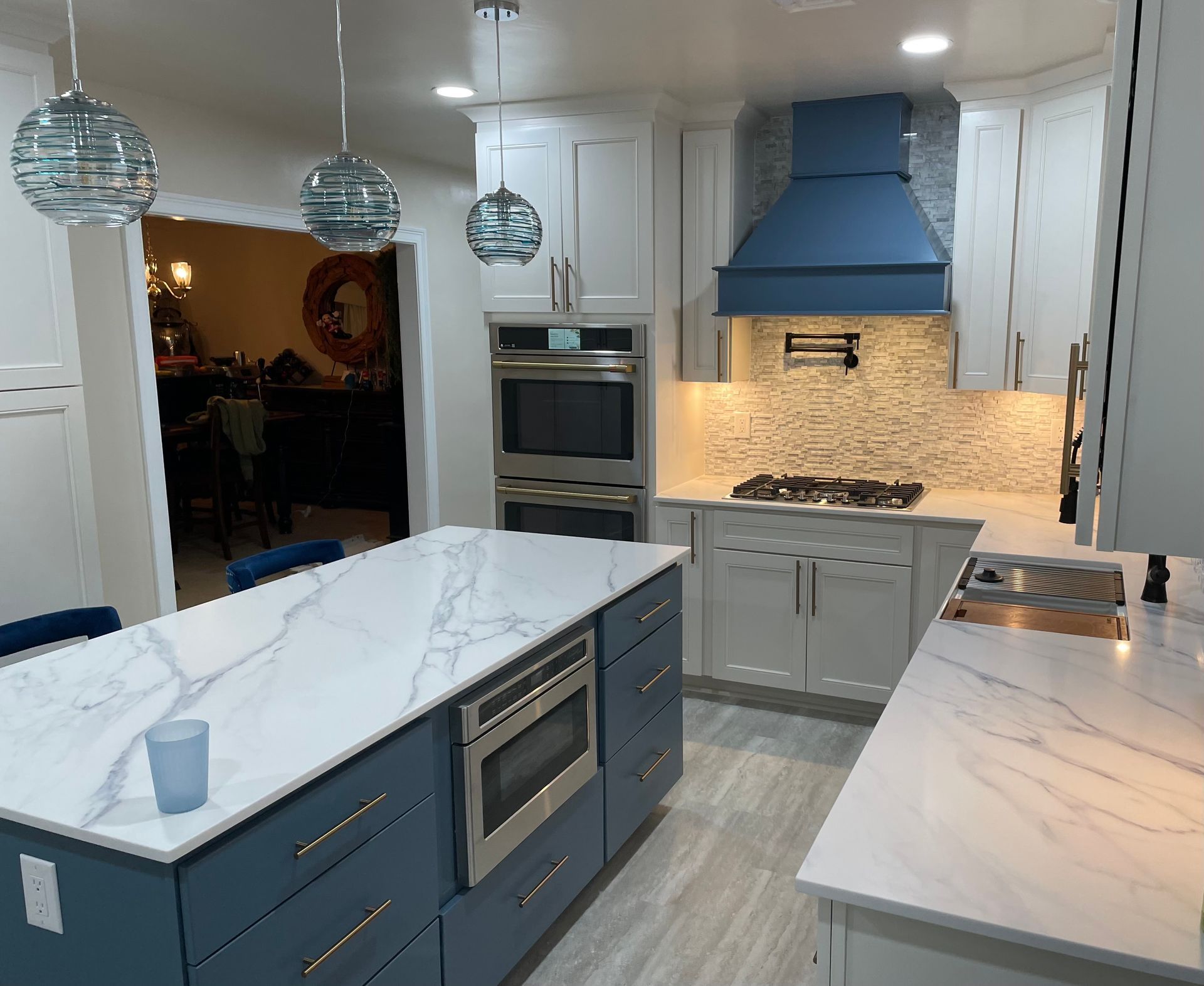A kitchen with blue cabinets and white counter tops