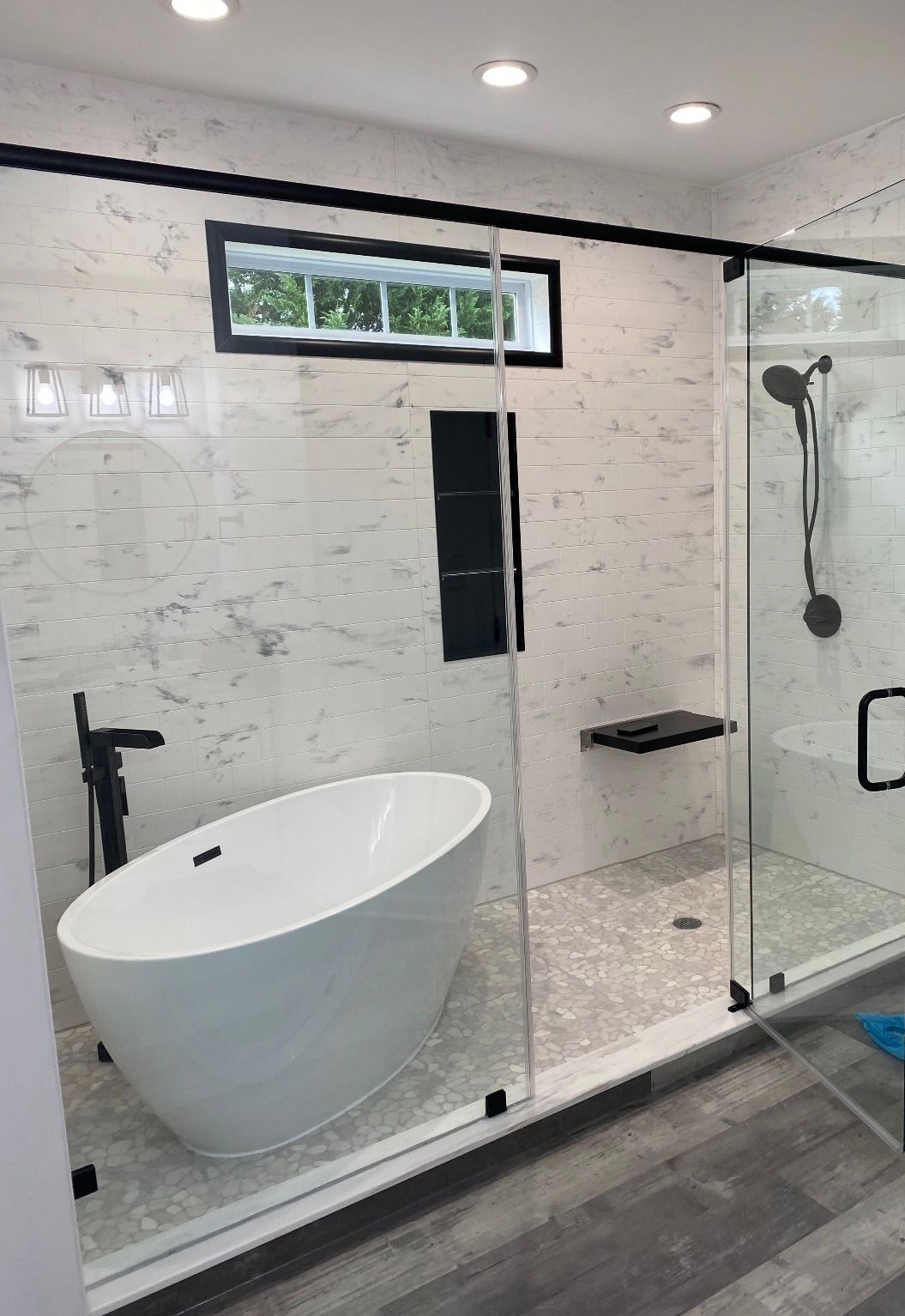 A bathroom with a tub , shower , and window.