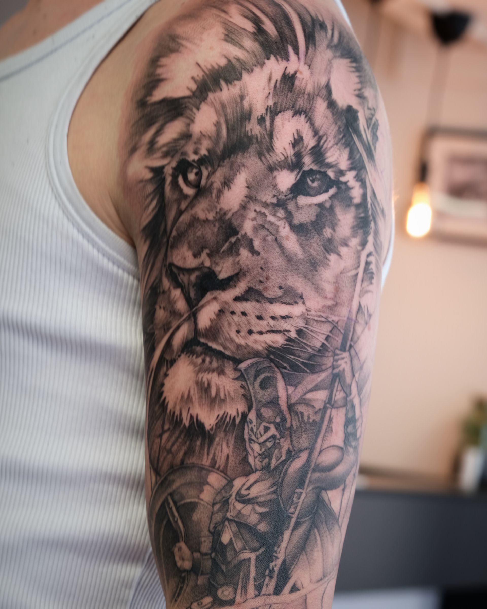 Ein Mann hat ein Löwentattoo auf seinem Arm