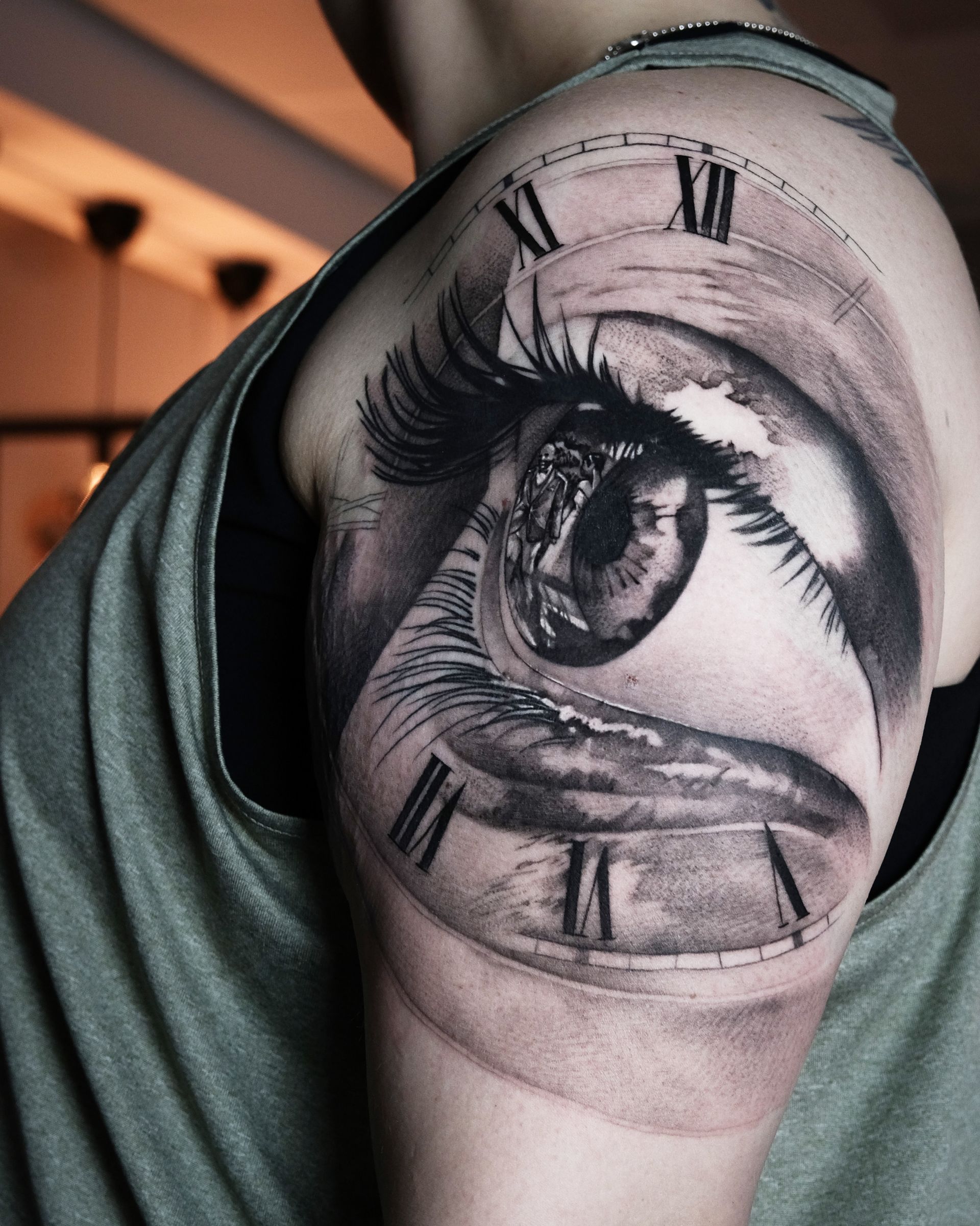 Ein Mann hat ein Tattoo eines Auges mit römischen Ziffern auf seiner Schulter