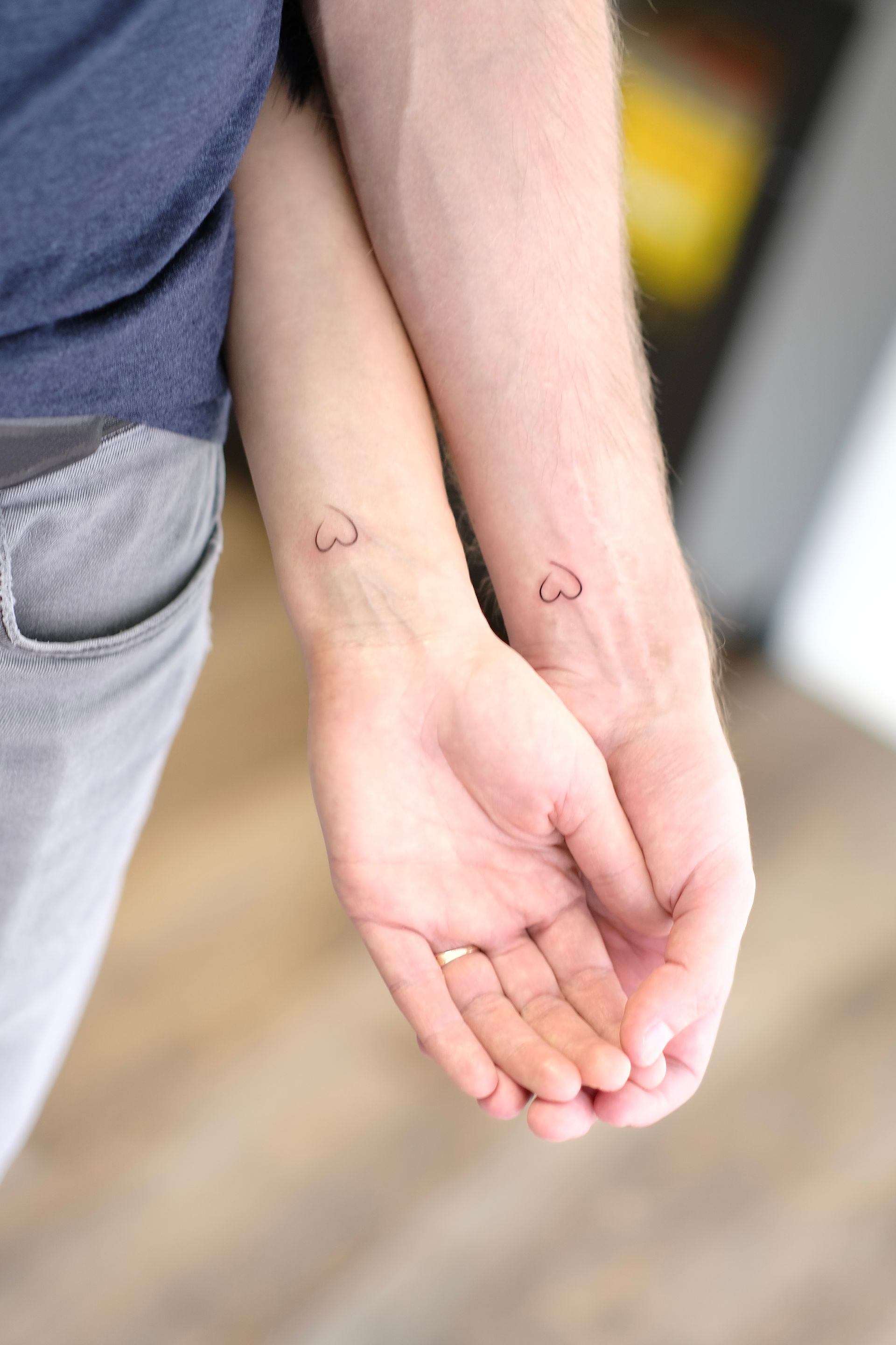 Ein Mann und eine Frau haben passende Tätowierungen an ihren Handgelenken.