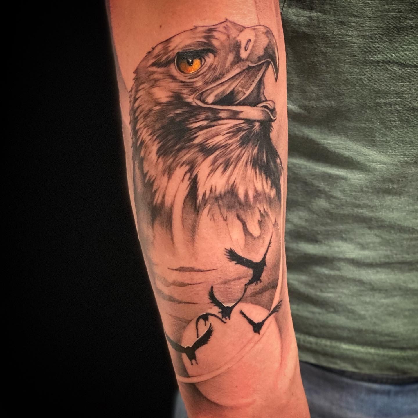 Ein Mann hat ein Adlertattoo auf seinem Arm
