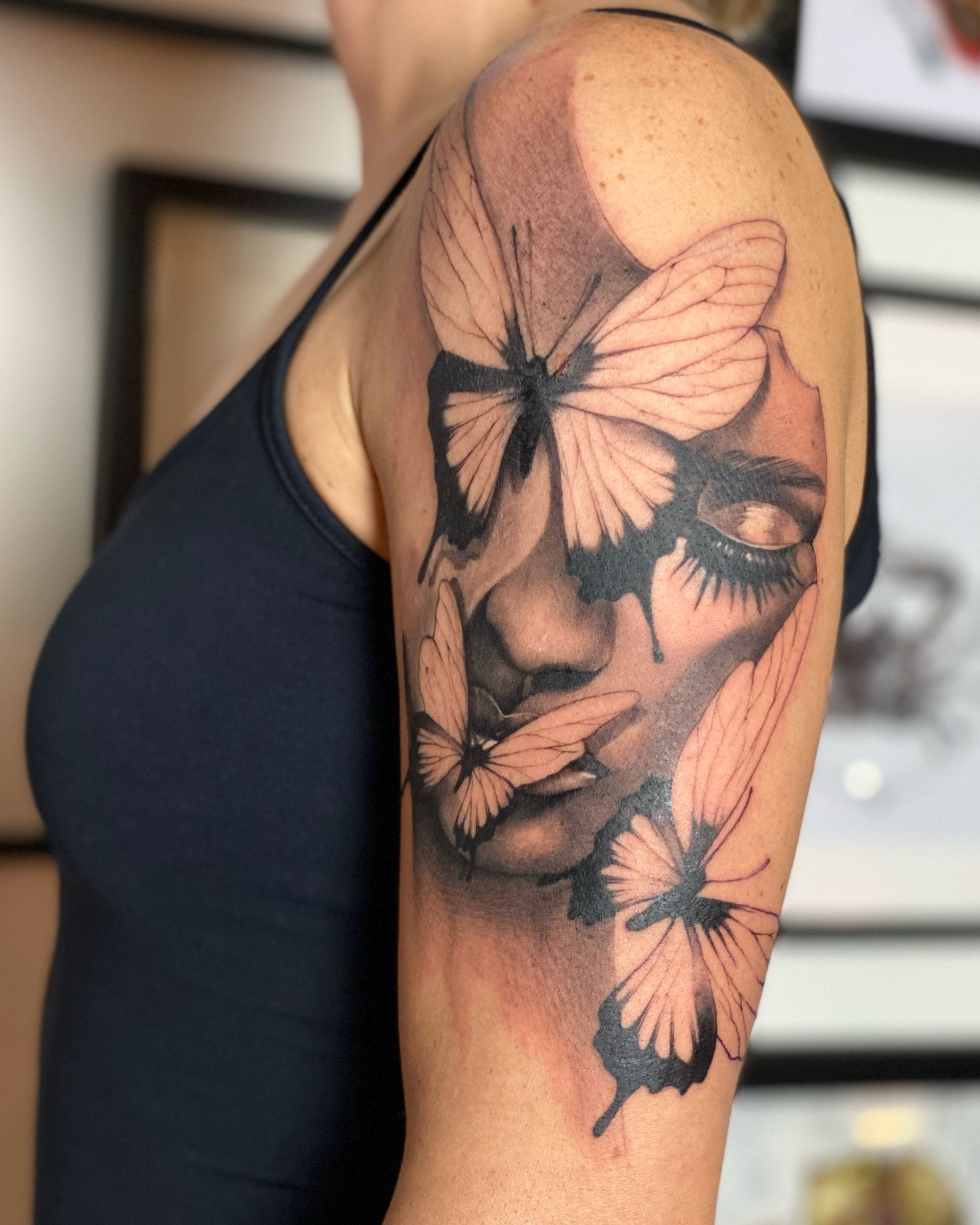 Eine Frau hat ein Schmetterlingstattoo auf ihrem Arm